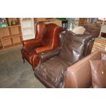 Two leather wing back armchairs