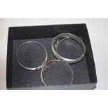 Three silver and one white metal bangle