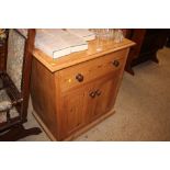 A modern pine side cupboard fitted single drawer