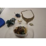 A tub of various brooches and necklaces