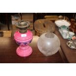 A Victorian pink glass oil lamp with etched glass