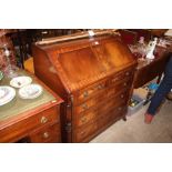 A reproduction mahogany bureau fitted two short ov