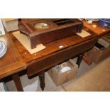 A stained pine drop leaf table