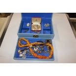 A blue jewellery box containing various costume je