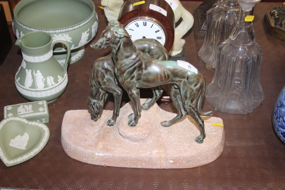 A bronze model of two greyhounds mounted on a terr