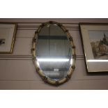 A gilt framed oval and bevel edged mirror