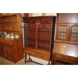 A mahogany and glazed cabinet on later stand fitte