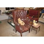 A brown leather button back upholstered armchair