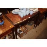 A mahogany two drawer writing table with red leath