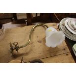 A brass light fitting with milk glass shade