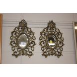 A pair of gilt metal and bevel edged mirrors in th