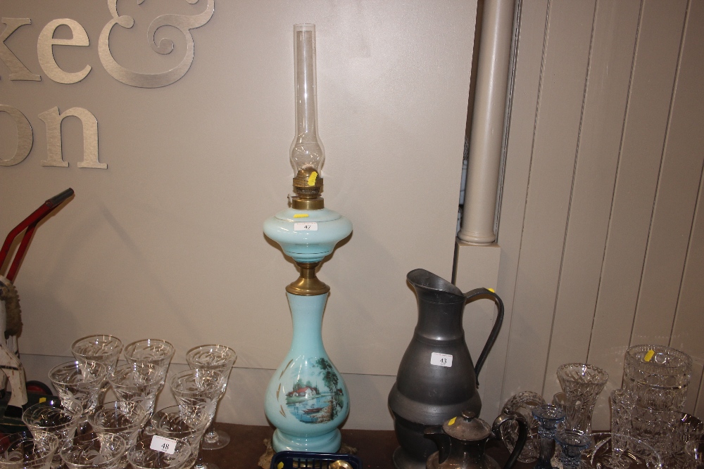 A turquoise glass oil lamp with painted decoration