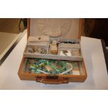 A brown leather jewellery box and contents of cost