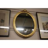 An oval gilt framed wall mirror