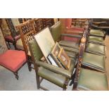 A pair of green leather and oak carver chairs