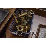 A basket of miniature brass candlesticks