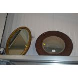 A carved oak circular framed wall mirror together