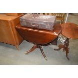 A reproduction mahogany drop leaf dining table
