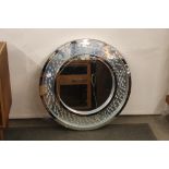 A circular silvered and diamante decorated wall mi