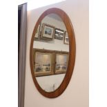 A teak framed oval wall mirror