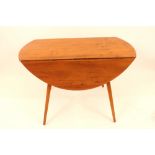 An light Ercol drop leaf kitchen table raised on t