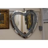 A silvered heart shaped wall mirror