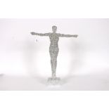 A silvered model of a gymnast with arms out-stretc