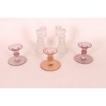 Three pink tinted glass dwarf candlesticks; and a