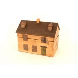 A wooden tea caddy in the form of a house