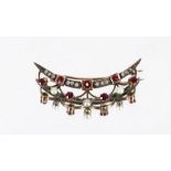 A yellow and white metal crescent bar brooch set with rubies and