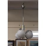 A chrome pendant light fitting, fitted three opaqu