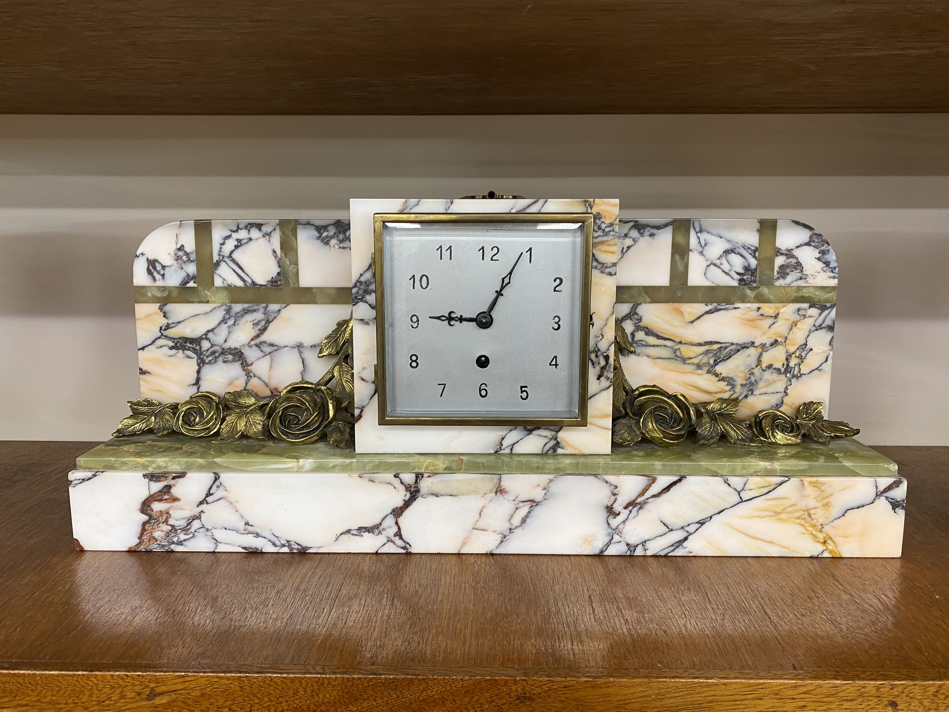 An Art Deco onyx and marble mantel clock, with floral gilt metal applied decoration, 55cm wide 23.