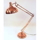 A large coppered angle poise floor lamp