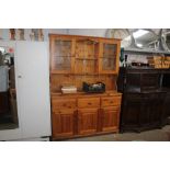 A modern pine dresser raised on cupboard base, fit