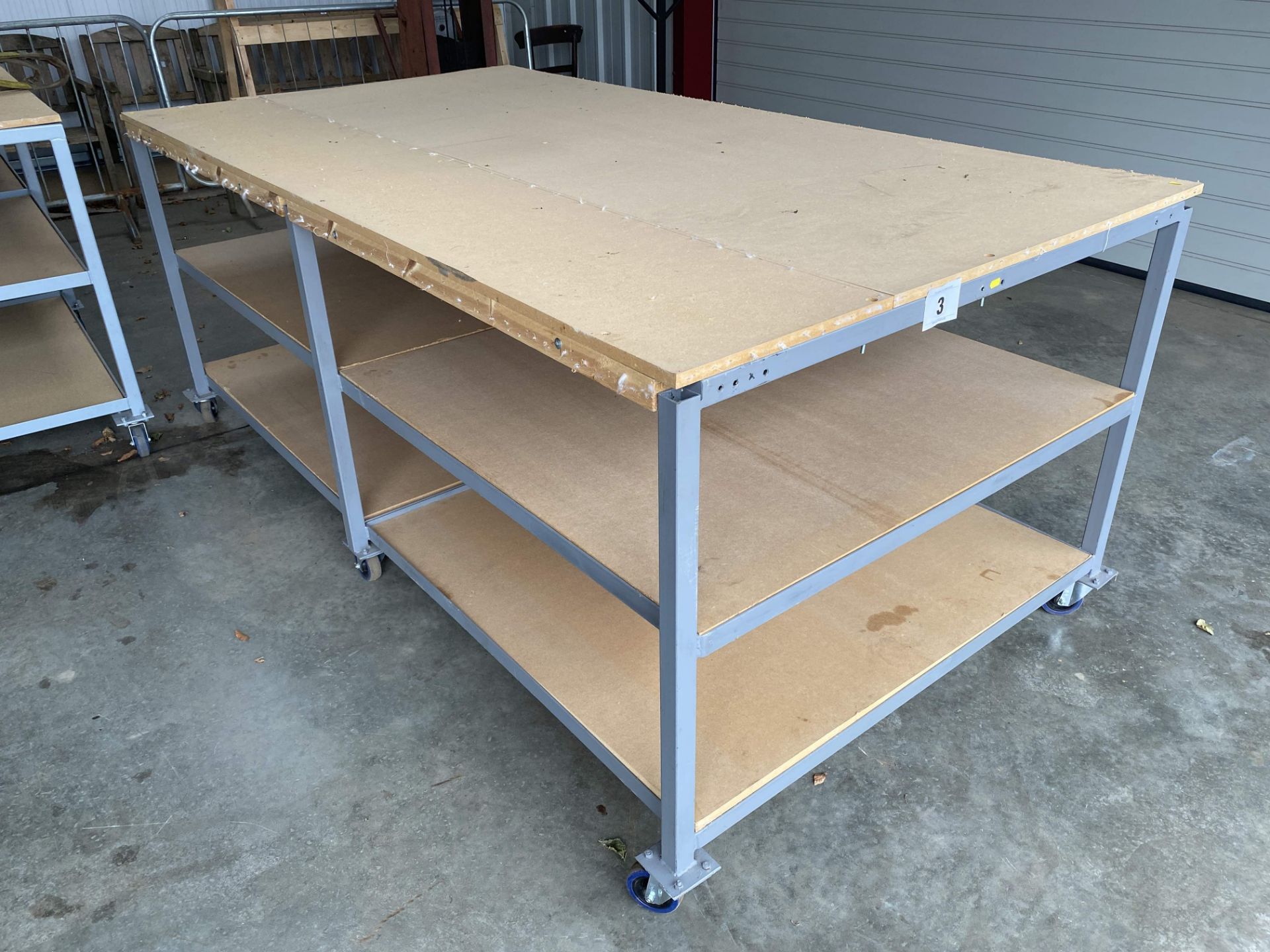 2.5m x 1.3m x 1m powder coated workbench on castors. With MDF shelves.