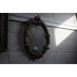 An oval gilt framed decorative wall mirror