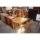 A light wood kitchen table; three spindle back cha