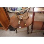 A circular topped coffee table, raised on claw and