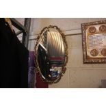 A gilt framed oval bevel edged wall mirror