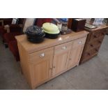 A modern pine effect dresser base; fitted three dr