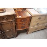 A yew wood bow fronted bedside chest fitted with t