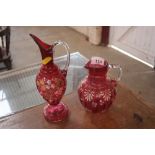 A cranberry glass and enamelled ewer and a baluster