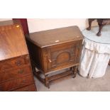 A small oak wedge shaped cupboard with carved pane