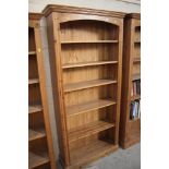 A tall stripped pine open fronted bookcase