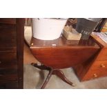 A reproduction mahogany drop leaf table