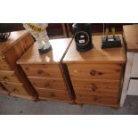 A pair of pine three drawer bedside chests