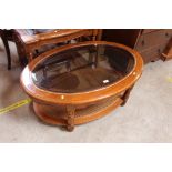 An oval glass topped coffee table; and similar rec