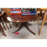 An elm circular table raised on tripod base