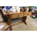 A carved oak side table fitted two drawers raised