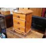 A pine bedside chest fitted three drawers